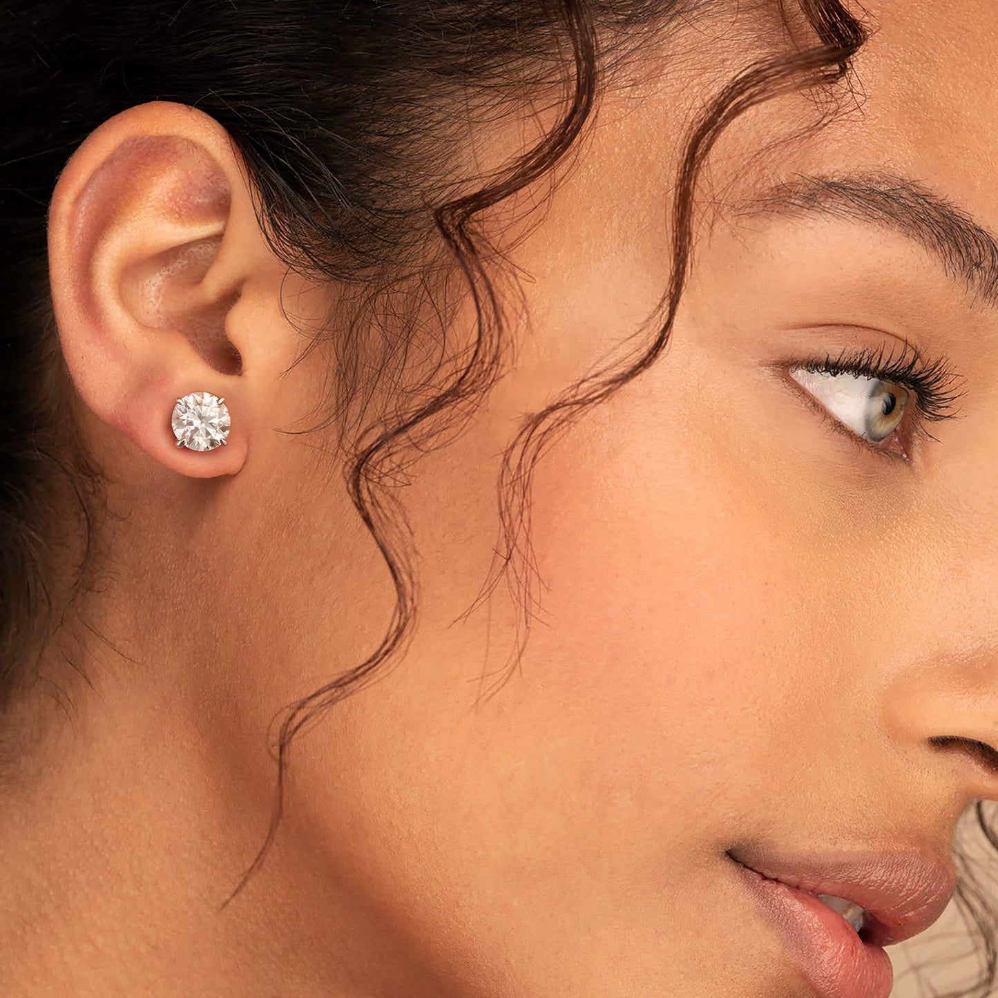 Orecchini unisex moissanite in argento 925 indossati da una donna, con moissanite da 1ct brillanti.